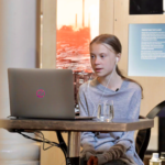 Showing Greta Thunberg, sitting at her computer. Participating in an online interview for Earth Day 2020.