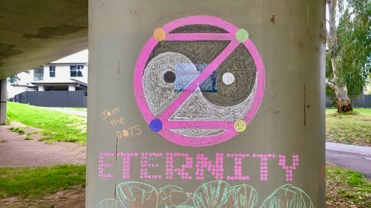 Example: Eternity written in chalk DOTS. dotZero and ying yang in background.